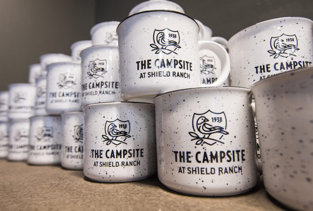 White mugs with the Campsite logo in black. 
