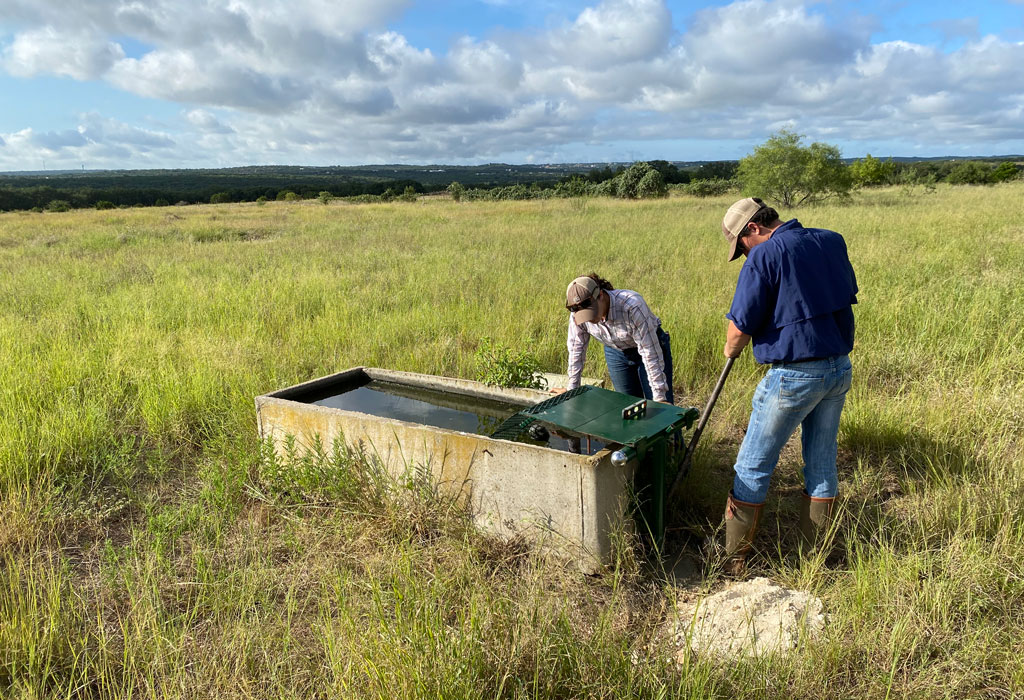 A man and women work on a water feature at Shield Ranch Barton Creek.